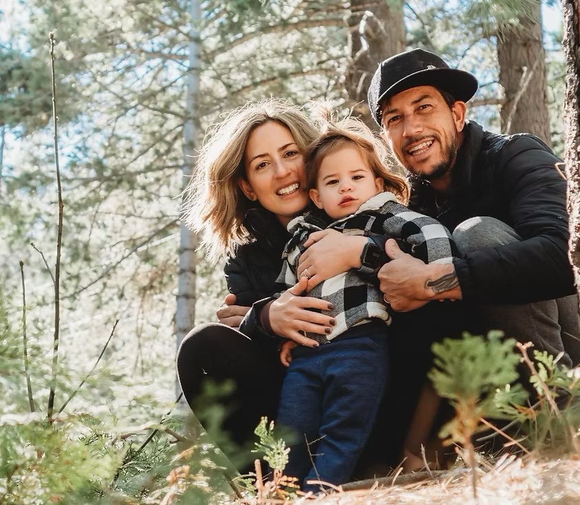 Lauren with her husband Toby and their child in the forest
